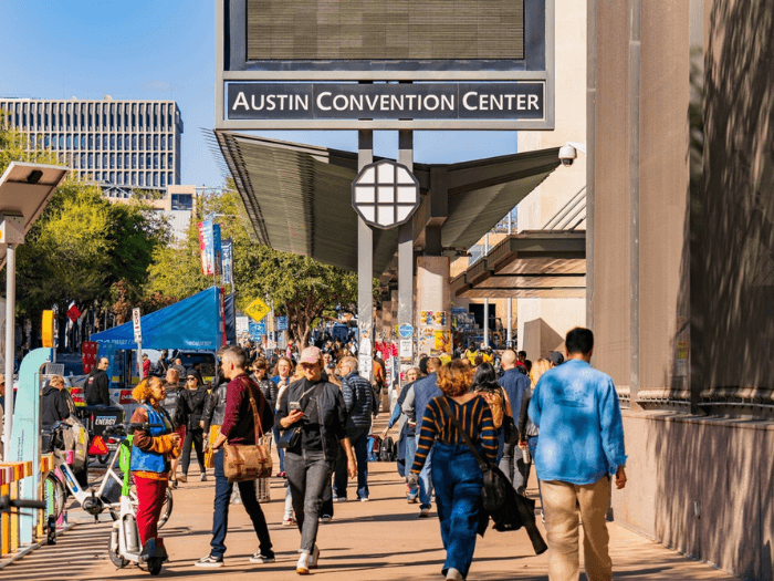 People walking on a busy street in Austin, Texas near the Austin Convention Center.